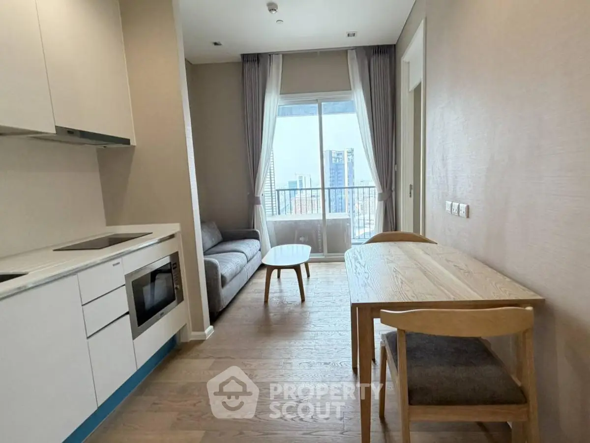 Modern apartment with open kitchen and cozy living area, featuring city view.