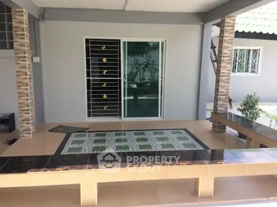 Charming outdoor patio with tiled flooring and modern sliding doors, perfect for relaxation.