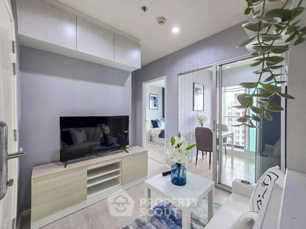 Modern living room with sleek furniture and balcony view in a stylish apartment.