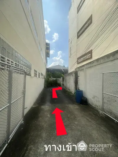 Narrow alleyway between buildings leading to a residential entrance