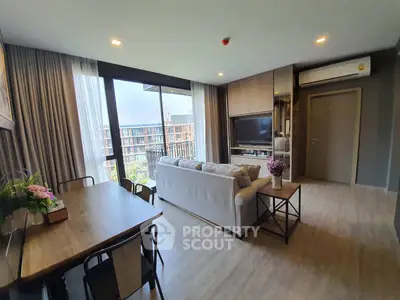 Modern living room with large windows and stylish decor in a high-rise apartment.
