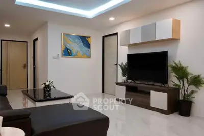 Modern living room with sleek furniture and stylish decor, featuring a flat-screen TV and contemporary artwork.
