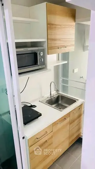 Compact modern kitchen with wooden cabinets and stainless steel sink