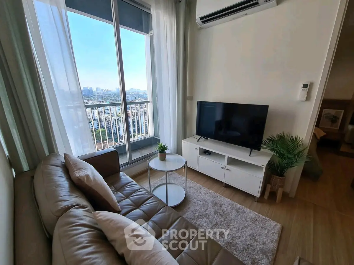 Modern living room with city view, featuring sleek furniture and air conditioning.