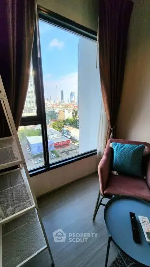 Cozy corner with city view, featuring a modern chair and ladder shelf by a large window.