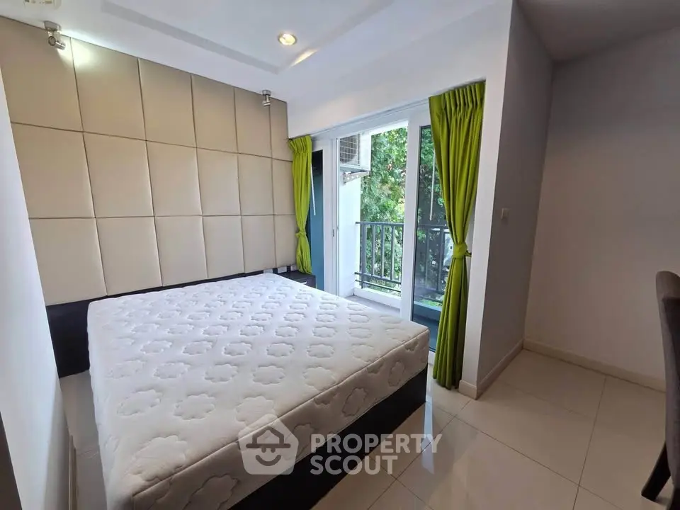 Modern bedroom with balcony access and stylish decor in a bright apartment.