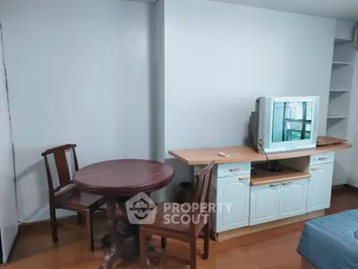Cozy living room with vintage TV and wooden furniture in a compact space