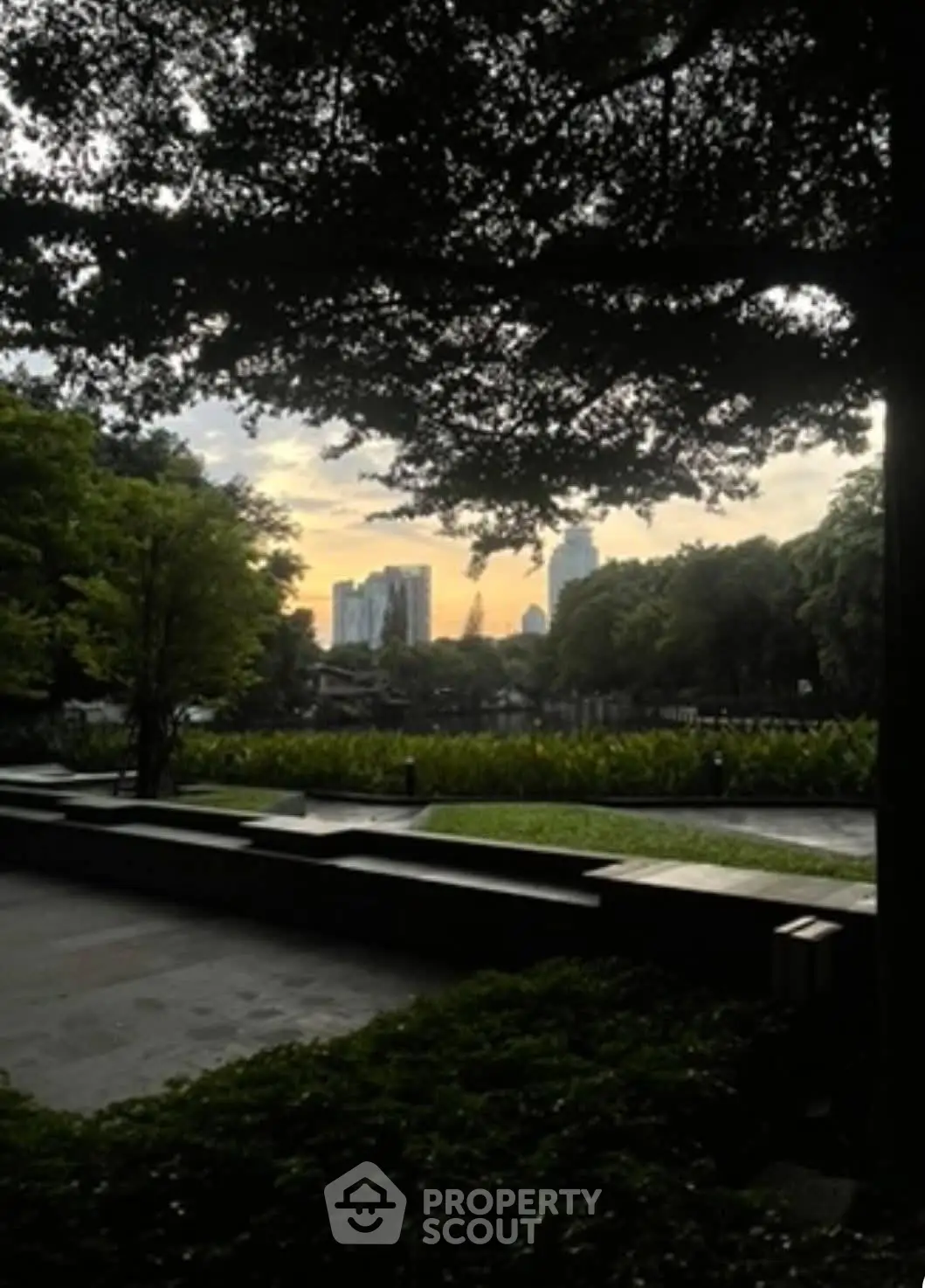 Scenic garden view with city skyline at sunset, perfect for urban nature lovers.