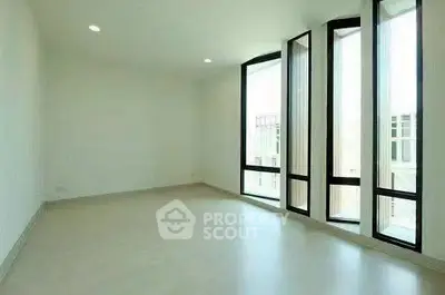 Spacious empty room with large windows and natural light