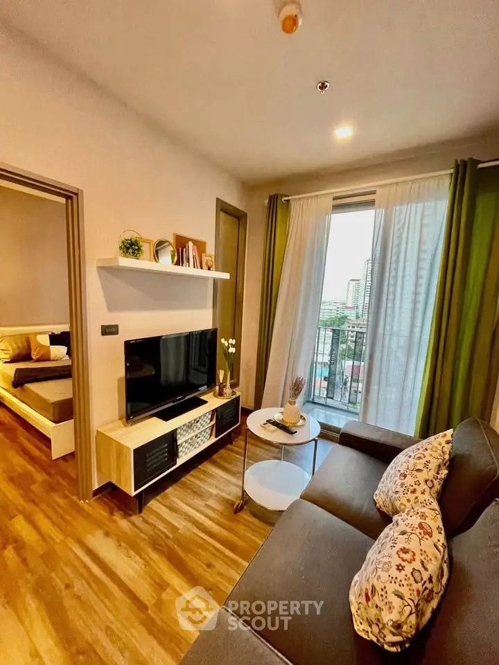 Charming living room with cozy sofa, TV, and balcony view in modern apartment.
