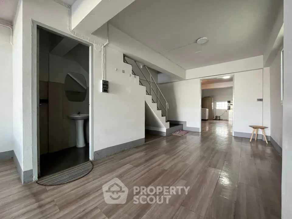 Spacious open-plan living area with modern staircase and wooden flooring