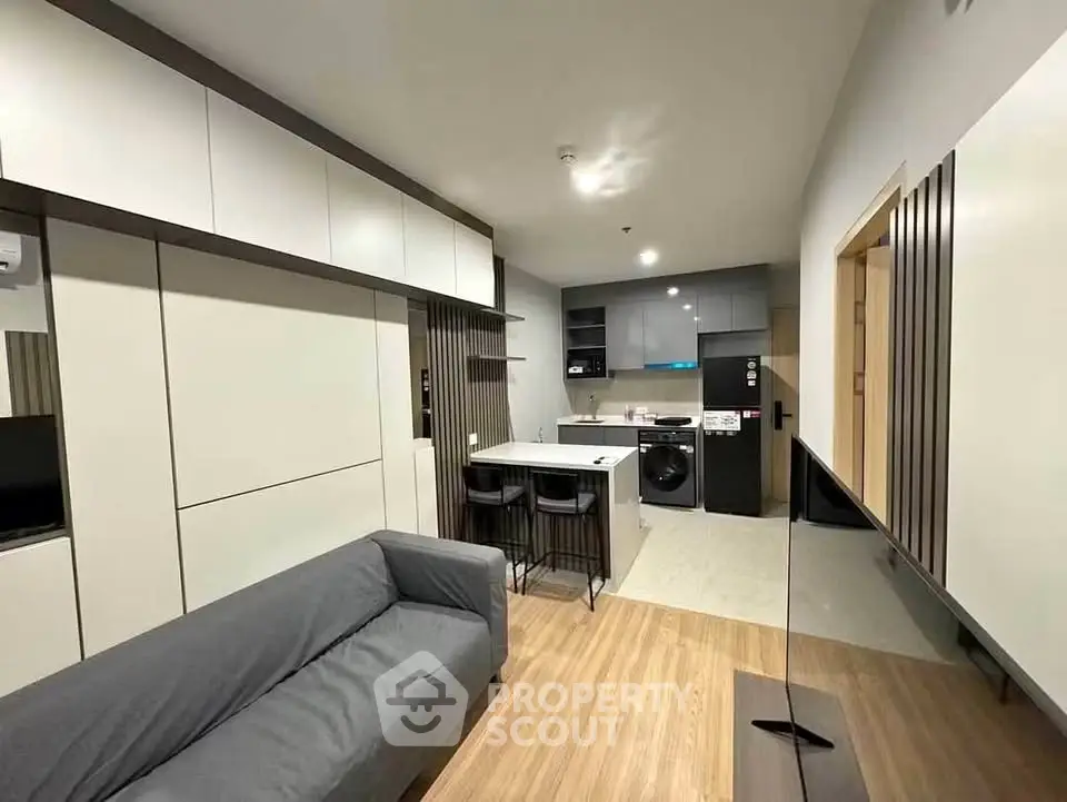 Modern open-layout living room with sleek kitchen and stylish furniture