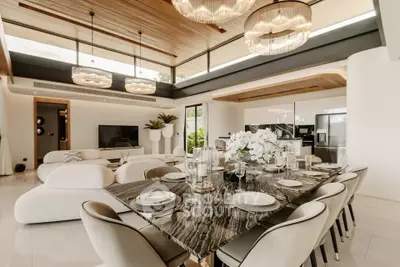 Luxurious open-plan living and dining area with elegant decor and modern lighting