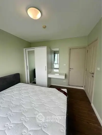 Cozy bedroom with green walls, wardrobe, and comfortable mattress in modern apartment.