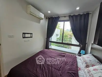Cozy bedroom with large window and air conditioning, featuring elegant curtains and a comfortable bed.