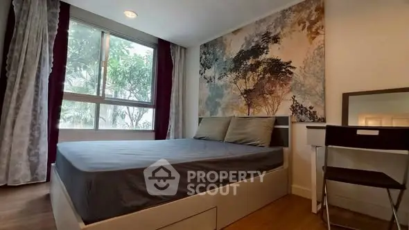 Cozy bedroom with large window and stylish wall art, perfect for relaxation.