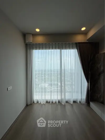 Spacious room with large window and balcony view, perfect for natural light lovers.
