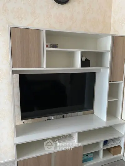 Modern living room with stylish TV unit and elegant wallpaper.