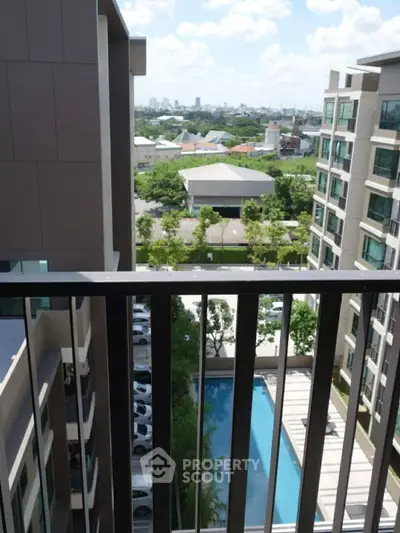Modern apartment balcony with pool and city view, perfect for urban living.