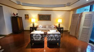 Elegant living room with classic furniture and warm lighting, featuring wooden floors and stylish decor.