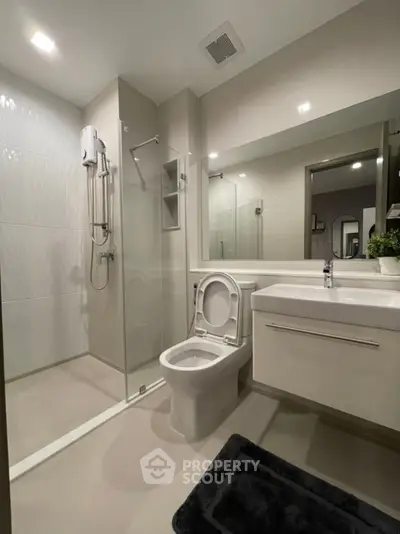 Modern bathroom with glass shower and sleek fixtures in a contemporary apartment.