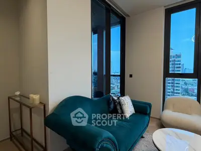 Stylish living room with plush teal sofa and city view, perfect for modern urban living.