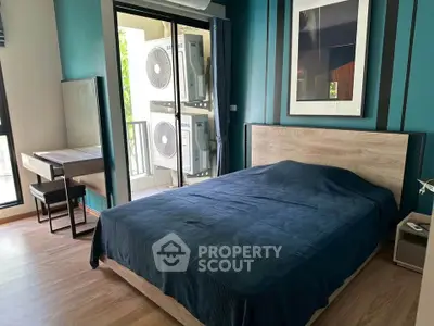 Modern bedroom with balcony access and air conditioning units view.