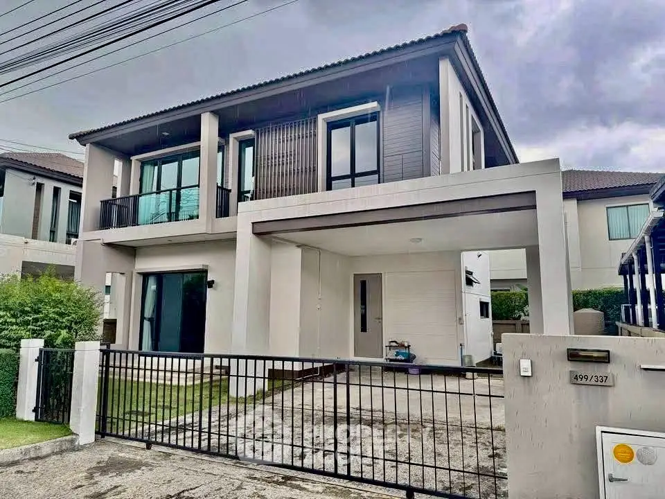 Modern two-story house with sleek design and spacious driveway in suburban neighborhood.