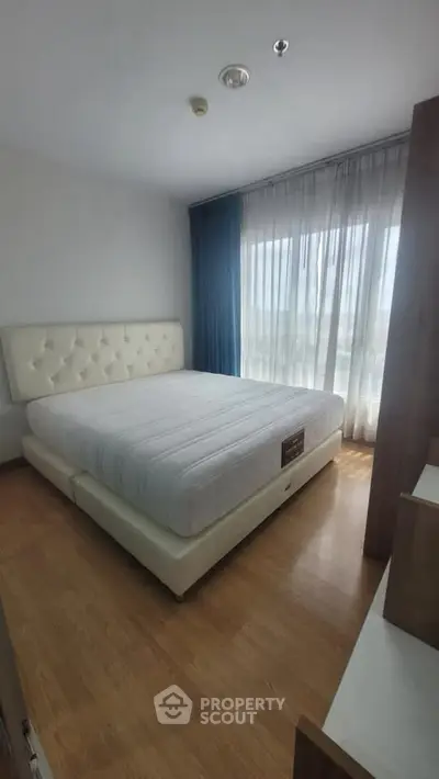 Cozy bedroom with large window and elegant bed in modern apartment.