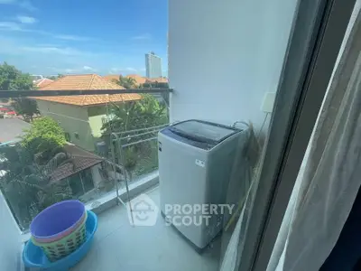 Charming balcony with washing machine and scenic view, perfect for urban living convenience.