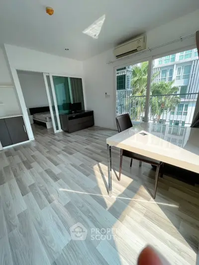 Modern apartment with open layout, large windows, and stylish flooring, offering a bright and inviting living space.