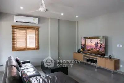 Modern living room with sleek furniture and large TV, featuring air conditioning and stylish decor.