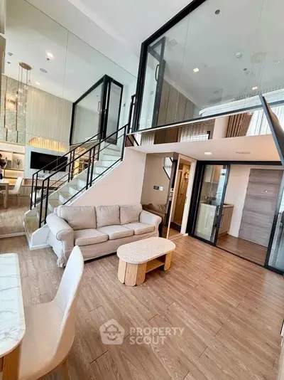 Luxurious modern living room with high ceilings and elegant staircase in a stylish duplex apartment.