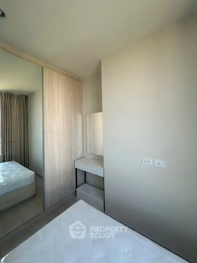 Modern bedroom with mirrored wardrobe and natural light