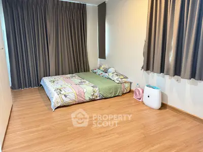 Cozy minimalist bedroom with wooden flooring and large windows