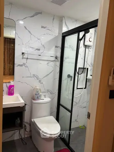 Modern bathroom with marble tiles and glass shower enclosure