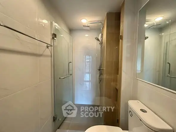 Modern bathroom with glass shower and sleek fixtures in a contemporary home.