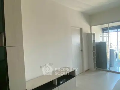 Modern living room with sleek storage and balcony access