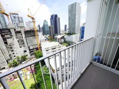 Modern urban balcony with city skyline view and construction cranes