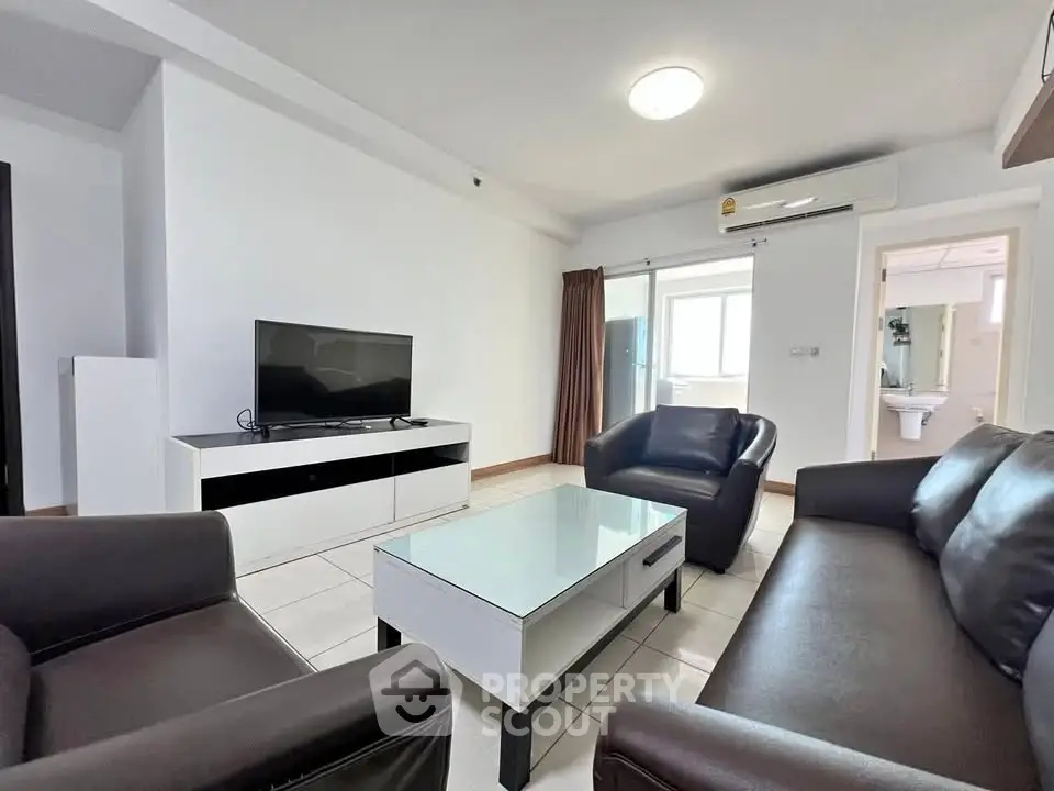 Modern living room with sleek furniture and TV in a bright apartment