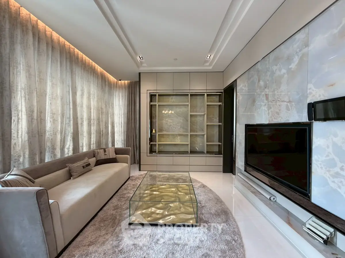 Luxurious living room with elegant decor, plush sofa, and modern entertainment setup.