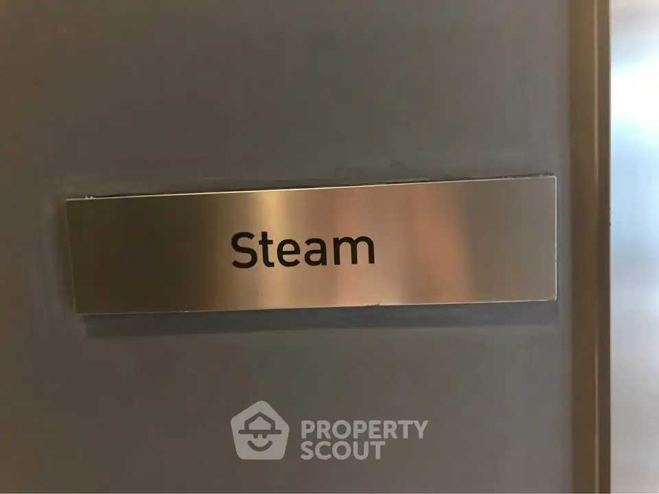 Modern steam room sign on sleek metal door in luxury building