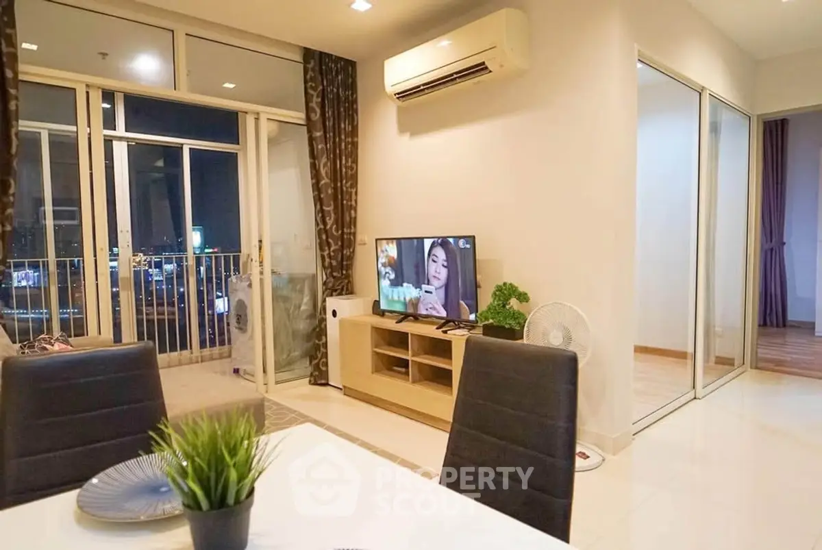 Modern living room with balcony view, air conditioning, and stylish decor in a contemporary apartment.