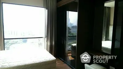 Modern bedroom with large windows and city view, featuring sleek furniture and ample natural light.