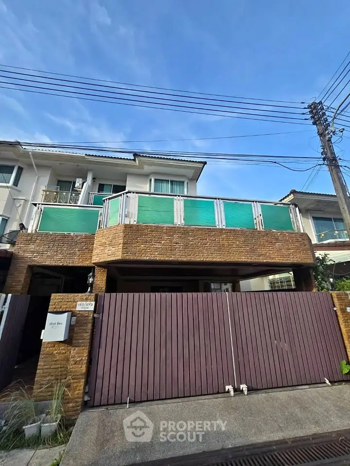 Charming two-story house with a spacious balcony and modern facade in a serene neighborhood.