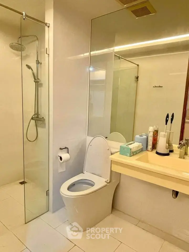 Modern bathroom with glass shower and sleek fixtures in a contemporary apartment.