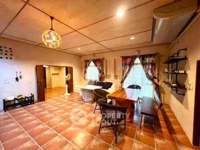Charming living room with rustic decor and vibrant lighting, featuring terracotta tiles and cozy seating area.