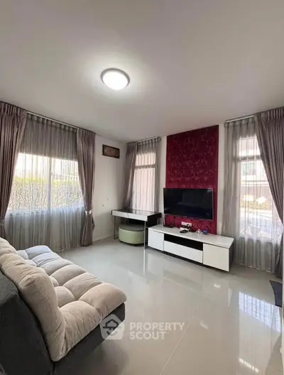 Modern living room with sleek furniture and large windows for natural light.