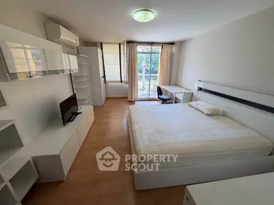 Spacious modern bedroom with balcony and stylish furniture in a bright apartment.