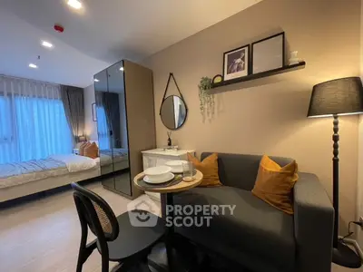 Cozy studio apartment with modern decor, featuring a compact dining area and stylish furnishings.
